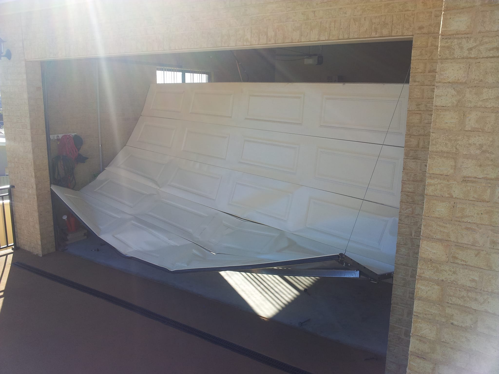 Damaged garage door before repair by Doormec in the Illawarra